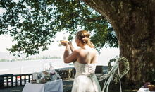 Die Braut verabschiedet ihren Mädchennamen, indem sie ihn mit Blütenblättern in die Luft wirft.