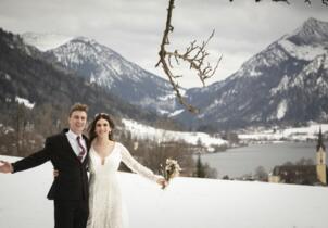 winter wedding in Bavaria: couple in the snow in front of Lake Schliersee