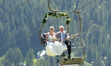 Berghochzeit auf der Sonna-Alp im Kleinwalsertal, Vorarlberg: Die Braut und ihr Vater kommen mit dem Sessellift