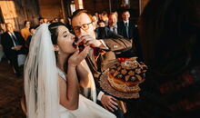 Das Brautpaar teilt das Brot bei einer Trauung mit jüdischen Elementen.