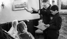 English wedding ceremony with Filipino tradition: Prayer over the couple under veil and cord.