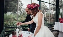 Das Brautpaar entzündet die Hochzeitskerze bei der freien Trauung mit dem weltlichen Trauredner Markus Schäfler in der Orangerie Bad Endorf