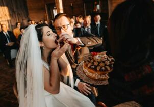 Das Brautpaar teilt das Brot bei einer Trauung mit jüdischen Elementen.