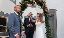 Die Braut verabschiedet ihren Mädchennamen, indem sie ihn mit Blütenblättern in die Luft wirft.