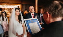 Der freie Theologe verliest und überreicht die Ketubba in der freien Trauung eines jüdisch-christlichen Paares.