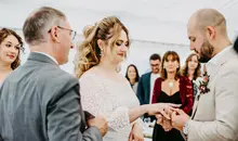 Brautpaar steckt sich die Eheringe an während der Trauung in der Alten Mühle Roggenburg