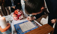 jüdisches Element in einer jüdisch-christlichen freien Trauung: das Hochzeitspaar unterzeichnet die Ketubba